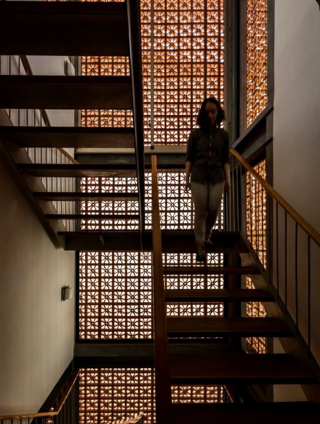 Staircase beside a warm illuminated breeze block screen
