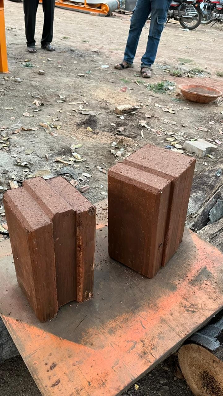 Freshly made reddish-brown interlocking brick units ready for construction
